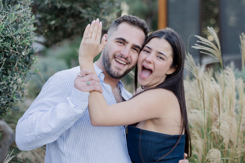Happy couple celebrates luxury surprise proposal with engagement ring.