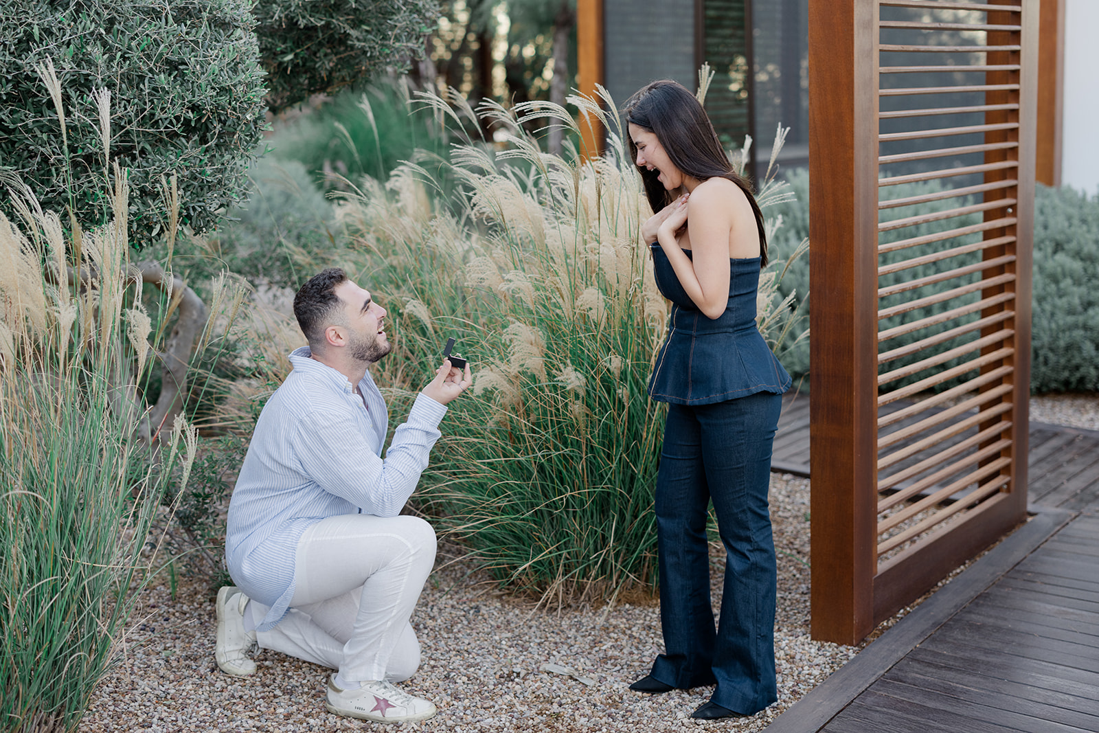 A romantic surprise proposal with the man on one knee and his partner reacting with pure joy, captured by luxury surprise proposal photographer Ignatios Kourouvasilis.